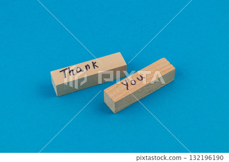 Wooden blocks with thank you written on them against a bright blue background 132196190