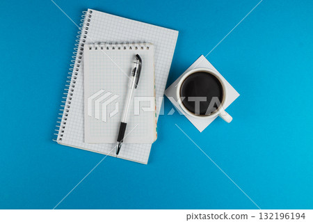 Notebooks, pen, and coffee cup on a blue background 132196194