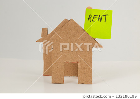 Miniature cardboard house model with bright rent sign 132196199