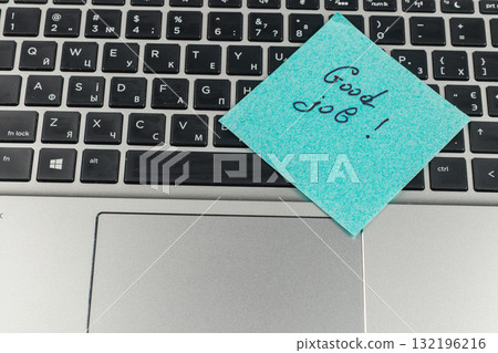 Good job note placed on laptop keyboard in a work setting Good job note placed on laptop keyboard in a work setting 132196216