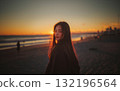 一個女人轉身，海灘上的日落 132196564