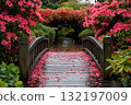 Wooden bridge in vibrant flower garden wet planks and petals 132197009