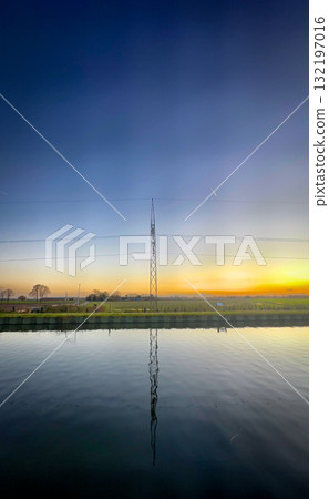 Serene Sunset Reflection featuring a Communication Tower amidst a beautiful scenery at dusk Serene Sunset Reflection featuring a Communication Tower amidst a beautiful scenery at dusk 132197016