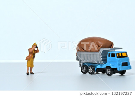 A woman photographs a fully loaded dump truck 132197227