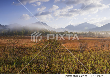 Autumn leaves of Odashirogahara and Mt. Nantai covered in morning mist 132197402