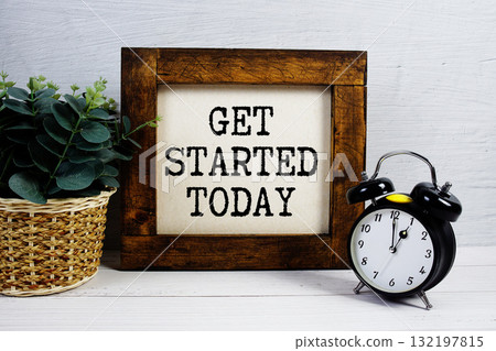 Get Started Today text with alarm clock on wooden background 132197815