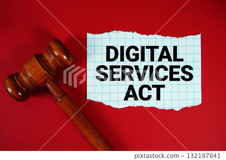 Digital Services Act text written on rip paper with wooden judgment gavel on red background 132197841