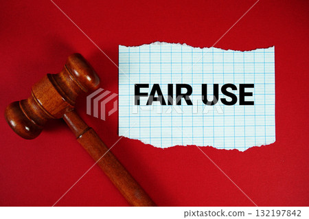 Fair Use text written on rip paper with wooden judgment gavel on red background 132197842