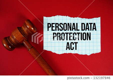 Personal Data Protection Act text written on rip paper with wooden judgment gavel on red background Personal Data Protection Act text written on rip paper with wooden judgment gavel on red background 132197846