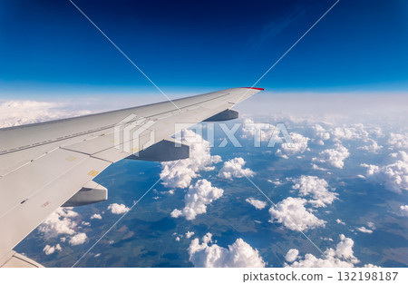 View from the airplane window at a beautiful cloudy sky and the airplane wing View from the airplane window at a beautiful cloudy sky and the airplane wing 132198187