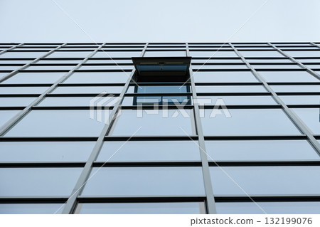 Glass facade of modern building with open window 132199076
