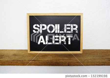Spoiler Alert text written on blackboard with wooden shelf and concrete background Spoiler Alert text written on blackboard with wooden shelf and concrete background 132199198
