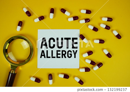 Acute Allergy text written on paper card with magnifying glass and medicine capsule on yellow background Acute Allergy text written on paper card with magnifying glass and medicine capsule on yellow background 132199237