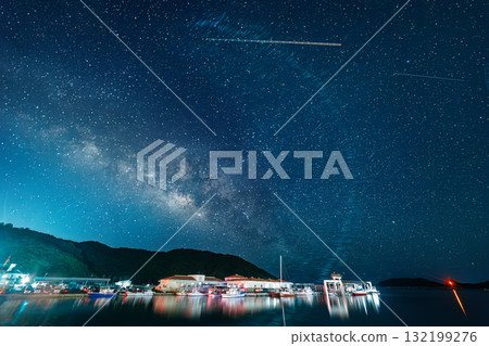 Long exposure starry sky photography on the beach with the humpback whale statue. The Milky Way and shooting stars were visible. Fishing boats and other things were visible in the harbor. Zamami Island Long exposure starry sky photography on the beach with the humpback whale statue. The Milky Way and shooting stars were visible. Fishing boats and other things were visible in the harbor. Zamami Island 132199276