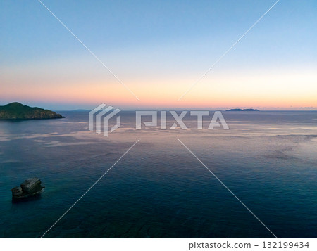 Aerial photography of the sunrise over the Kerama Islands from Zamami Port using a drone. Zamami Port, Zamami Island, Kerama Islands, Shimajiri District, Okinawa Prefecture 132199434