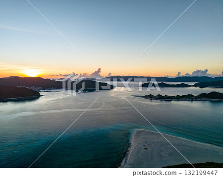 Aerial photography of the sunrise over the Kerama Islands from Zamami Port using a drone. Zamami Port, Zamami Island, Kerama Islands, Shimajiri District, Okinawa Prefecture 132199447