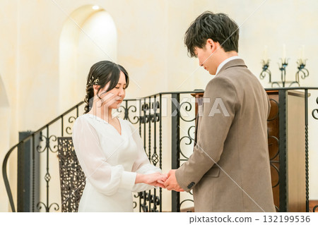 Bride and groom facing each other in a church / chapel (wedding / bridal) 132199536