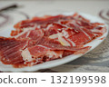 Slices of Iberian ham on a white plate, Spanish traditional food 132199598
