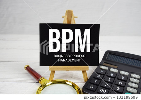 BPM Business Process Management text with magnifying glass and calculator on wooden background 132199699