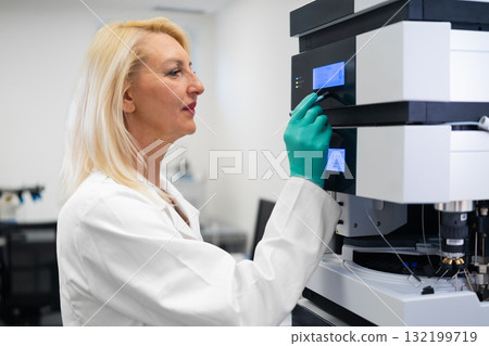 Professional technician performing maintenance and calibration of HPLC system for reliable laboratory results. Professional technician performing maintenance and calibration of HPLC system for reliable laboratory results. 132199719