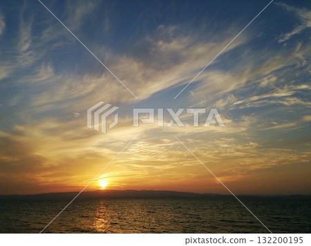 金色的天空，蔚藍的天空，太陽落在海面上，彷彿就要沉沒消失 132200195
