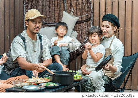 Family eating on a wooden deck (glamping, outdoor, villa, cottage) Family eating on a wooden deck (glamping, outdoor, villa, cottage) 132200392