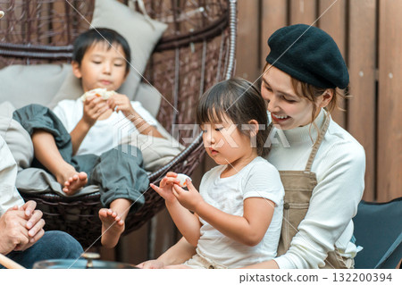 Family eating on a wooden deck (glamping, outdoor, villa, cottage) Family eating on a wooden deck (glamping, outdoor, villa, cottage) 132200394