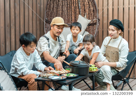 Family eating on a wooden deck (glamping, outdoor, villa, cottage) 132200399