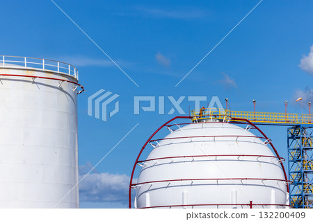 White crude oil storage tanks at petroleum refinery industrial plant, Fuel gas containers in factory area, Energy industry infrastructure, Oil and Gas storage tank blue sky background. White crude oil storage tanks at petroleum refinery industrial plant, Fuel gas containers in factory area, Energy industry infrastructure, Oil and Gas storage tank blue sky background. 132200409