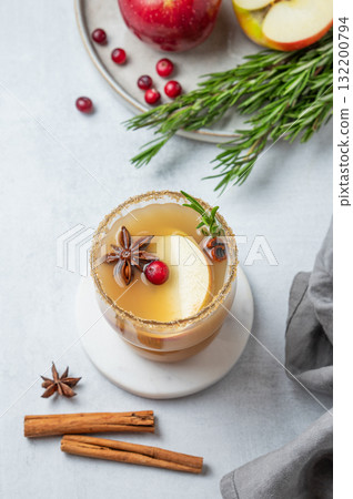 Hot apple cider with cinnamon, anise, brown sugar and rosemary in a glass on a light background Hot apple cider with cinnamon, anise, brown sugar and rosemary in a glass on a light background 132200794