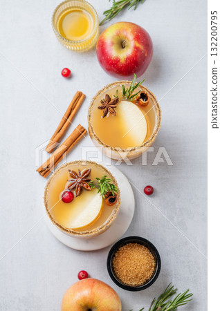 Flat lay of apple cider with cinnamon, anise, brown sugar and rosemary on a light background 132200795