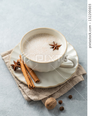 Traditional Indian masala chai tea with milk and spices on a light background. 132200803