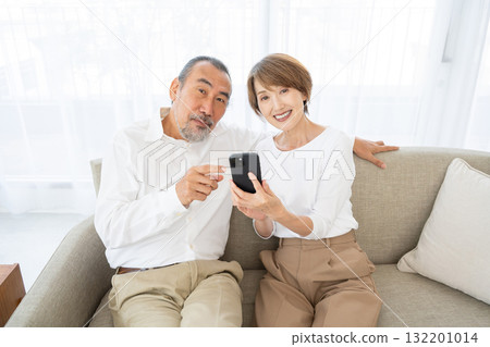 A smiling senior couple who operates a smartphone A smiling senior couple who operates a smartphone 132201014