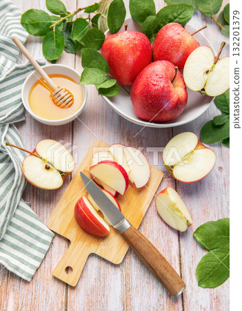 Red apples, honey, and knife on cutting board 132201379