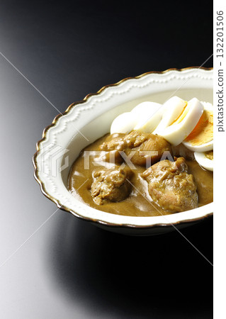 Chicken curry with boiled egg on a black background Chicken curry with boiled egg on a black background 132201506
