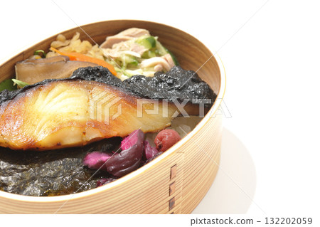 A bento lunch box with seaweed and grilled silver cod served in a bento box, photographed against a white background A bento lunch box with seaweed and grilled silver cod served in a bento box, photographed against a white background 132202059