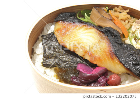 A bento lunch box with seaweed and grilled silver cod served in a bento box, photographed against a white background A bento lunch box with seaweed and grilled silver cod served in a bento box, photographed against a white background 132202075