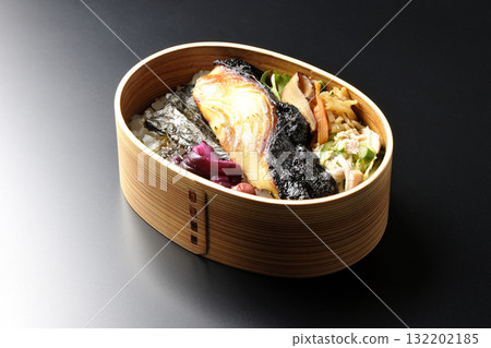 一張便當盒,裡面有海藻和西京風味醬汁烤銀鱈魚,以黑色背景拍攝 一張便當盒,裡面有海藻和西京風味醬汁烤銀鱈魚,以黑色背景拍攝 132202185