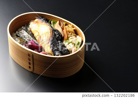 一張便當盒，裡面有海藻和西京風味醬汁烤銀鱈魚，以黑色背景拍攝 132202186