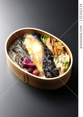 A bento lunch box with seaweed and grilled silver cod in a saikyo style sauce, photographed against a black background A bento lunch box with seaweed and grilled silver cod in a saikyo style sauce, photographed against a black background 132202214