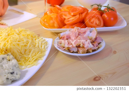 Prepares the ingredients for pizza tomatoes, cheese and bacon. Prepares the ingredients for pizza tomatoes, cheese and bacon. 132202351