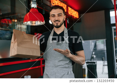 Order in package is ready. Man is serving delicious street food 132203450