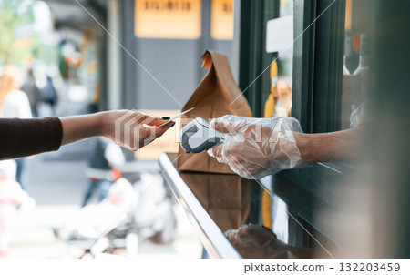 Customer is making payment by credit card. Man is serving delicious street food 132203459