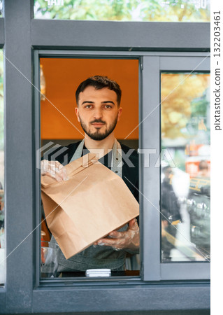 Order in package is ready. Man is serving delicious street food Order in package is ready. Man is serving delicious street food 132203461