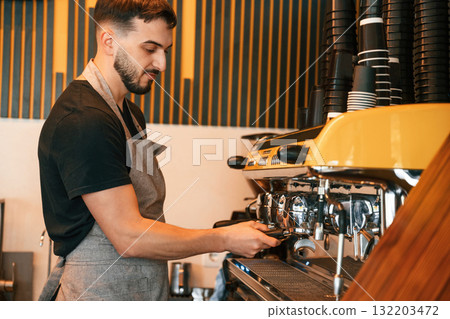Pours a drink by using special machine. Man is serving delicious street food Pours a drink by using special machine. Man is serving delicious street food 132203472