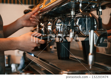 Pours a drink by using special machine. Man is serving delicious street food Pours a drink by using special machine. Man is serving delicious street food 132203474