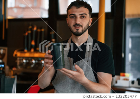 Drink is in hand. Man is serving delicious street food 132203477