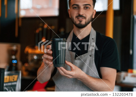 Drink is in hand. Man is serving delicious street food 132203478