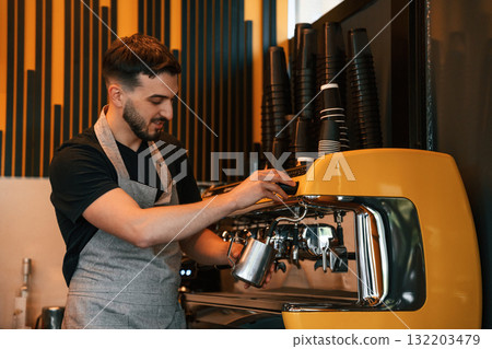Pours a drink by using special machine. Man is serving delicious street food Pours a drink by using special machine. Man is serving delicious street food 132203479