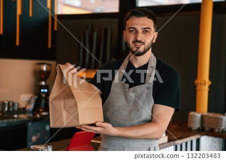 Your order is packaged and ready. Man is serving delicious street food 132203483